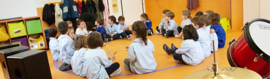 Niños y profesora sentados en el suelo en círculo