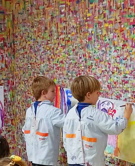 Dos niños pintando la pared