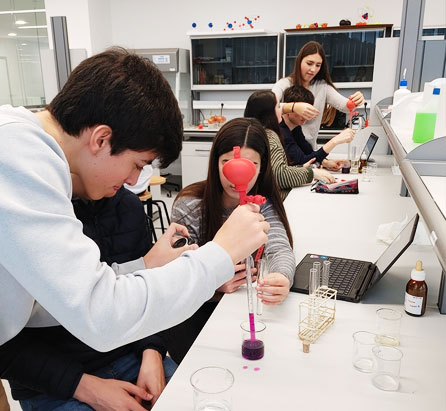 Alumnos del área de ciencia y tecnología, analizando líquidos de colores con probetas